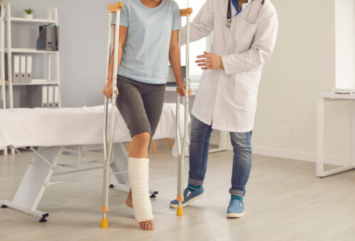 injury woman on crutches doctor helping