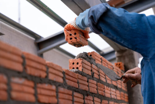 construction worker cementing bricks